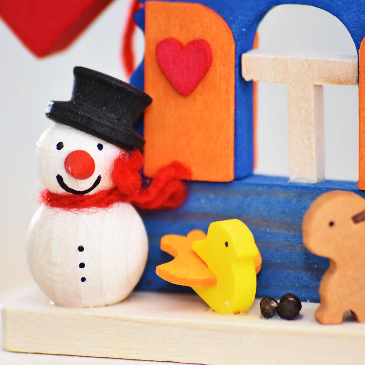 Haus Schneemann als Baumschmuck mit Holzstapel