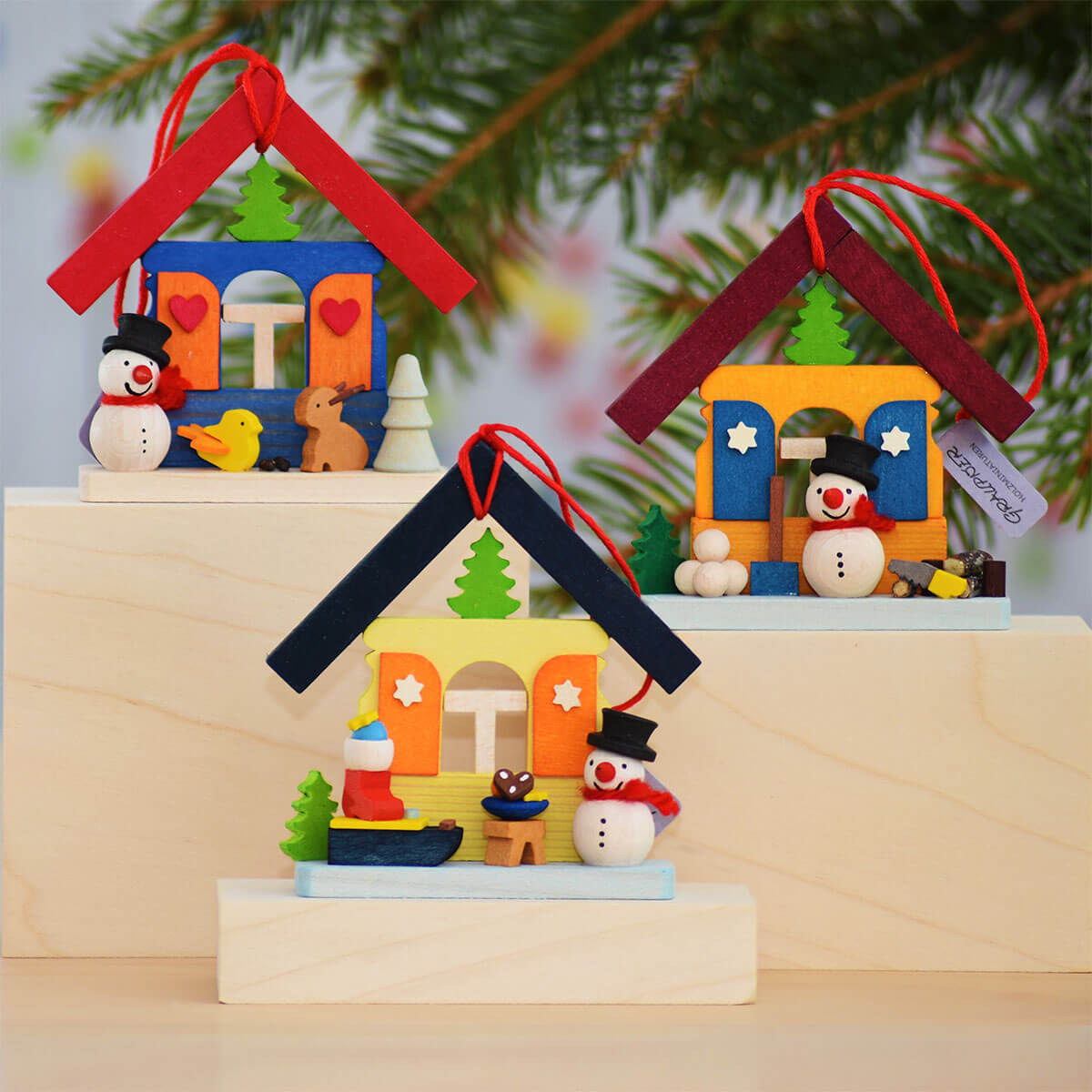 Haus Schneemann als Baumschmuck mit Holzstapel