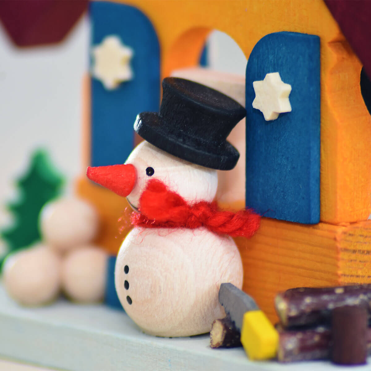Haus Schneemann als Baumschmuck mit Holzstapel
